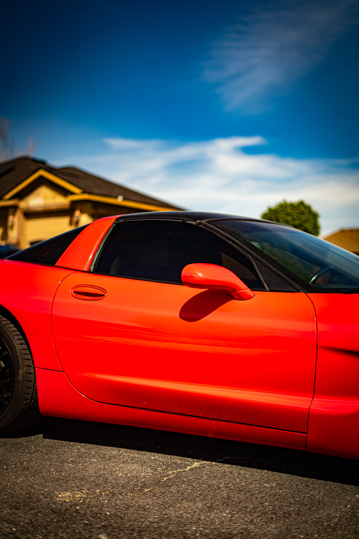 Ceramic tint on red Chevrolet Corvette — side window close-up, Chroma Auto Lab