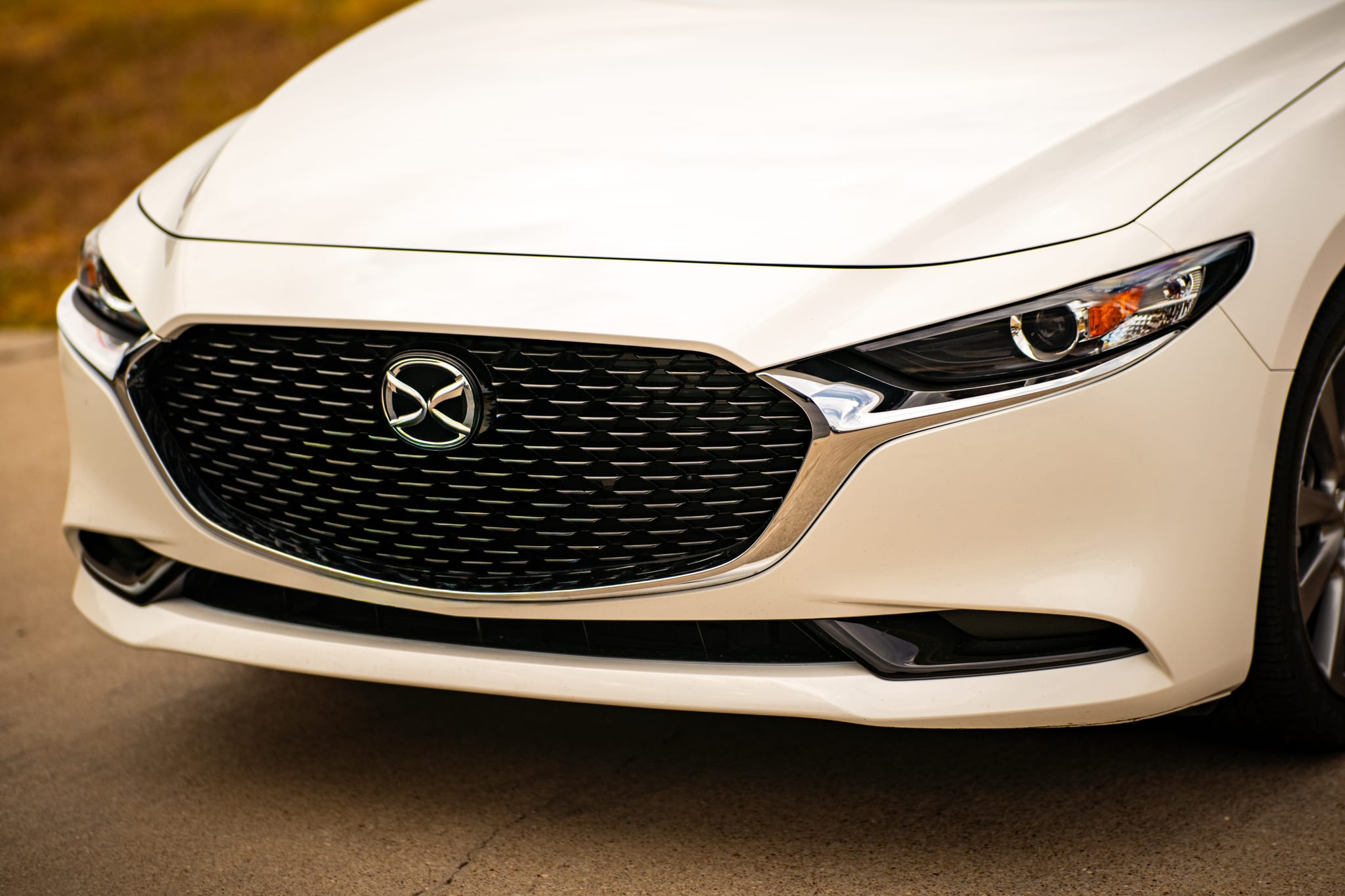 Mazda 3 front end before a chrome delete, with chrome trim around the grille