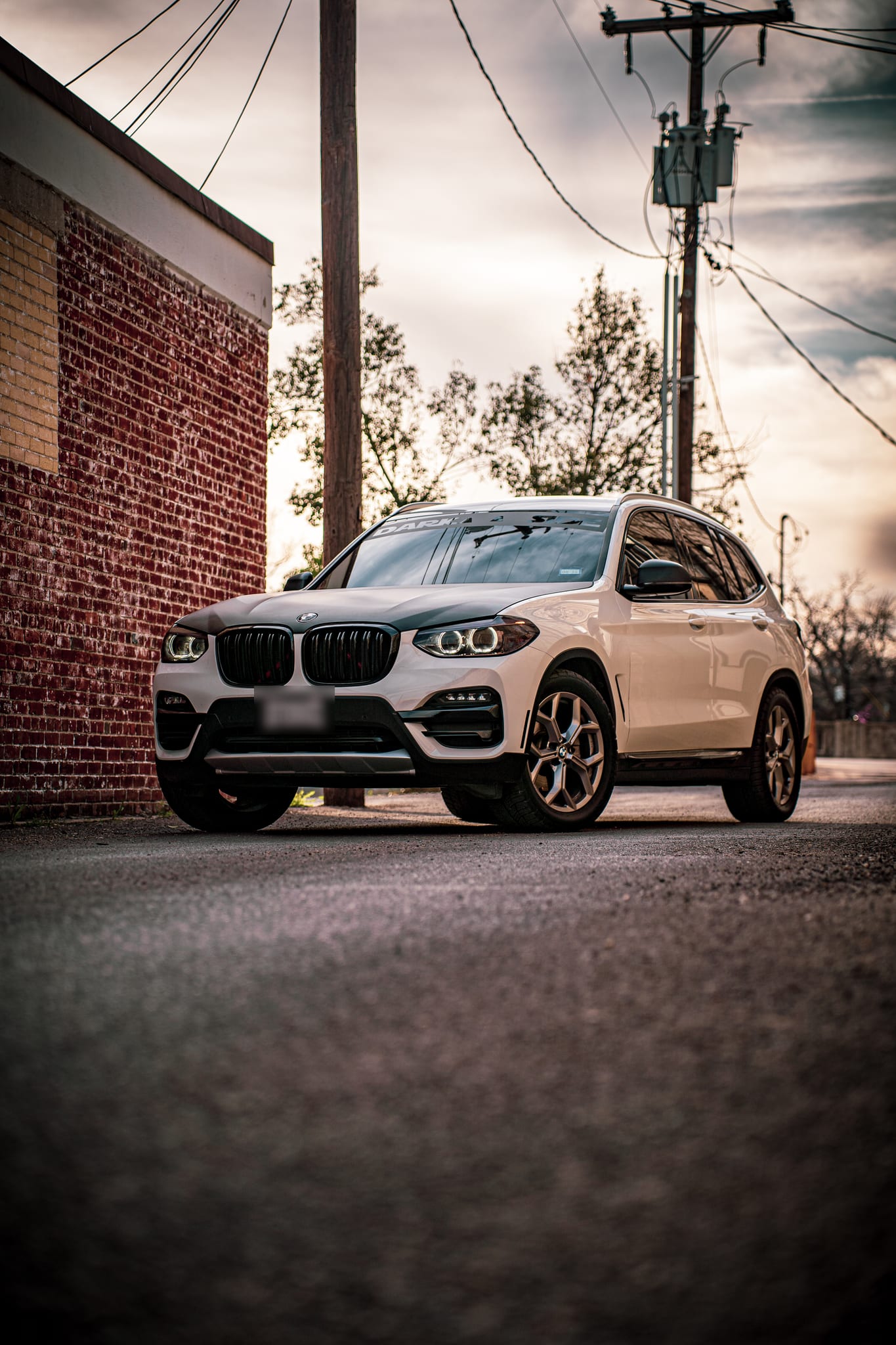 Window tint on a white BMW X3 in an alley
